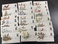 Photo showing 20 US First Day of Issue Covers from 1982 featuring flowers and birds, arranged in five rows, highlighting the vibrant stamps and detailed cover art.