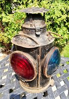 Three-quarter view showing convex red and blue glass lenses and domed chimney