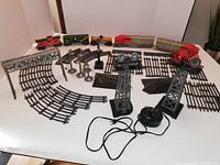Overview photo showing all train cars, track pieces, lamps, junctions, and accessory structures arranged on a table.