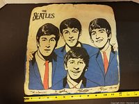 Front of pillow showing printed illustration of The Beatles band members with signatures and 'The Beatles' text