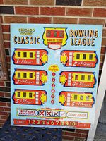 Front view of colorful Chicago Coin Classic Bowling League arcade game back glass panel showing player scoring areas, scores, and frames on a light blue background.
