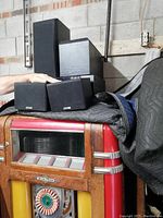 Four Kenwood speakers of different sizes stacked and arranged together, illustrating all speakers included in the lot.