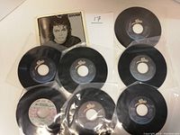Photo of all eight Michael Jackson 45 RPM records arranged in two rows with one record in an original picture sleeve showing Michael Jackson's portrait
