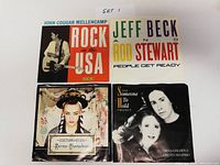 Front view of four 45 RPM records with original picture sleeves labeled as Set 1; includes John Cougar Mellencamp, Jeff Beck & Rod Stewart, Culture Club, and Diana Goldman & Steven Shapiro