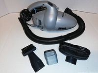 Full view of Shark Turbo hand vacuum with attached flexible hose and three accessory nozzle attachments laid out in front