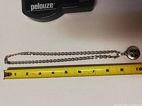 Full view of silver chain measuring about 10 inches with round pendant clasp and chain links.