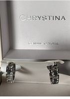 Close-up photo of both crystal earrings in white Chrystina jewelry box showing brand and 'Genuine Crystal' text
