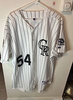 White pinstriped Colorado Rockies jersey front with number 54 and team patch on sleeve