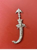 Moroccan dagger sheathed in ornate silver scabbard with ram head hallmark on hilt.