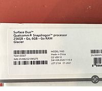 Packaging label with Surface Duo specifications: Qualcomm Snapdragon processor, 256GB storage, 6GB RAM, Glacier color, model 1930