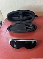 Glasses and open case with cable inside mesh pocket