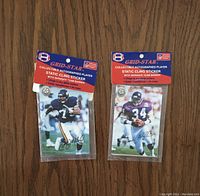 Two Grid-Star collectible autographed static cling stickers in original packaging showing NFL players with team banners.