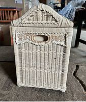 Front view of the wicker basket showing carved floral design and handle