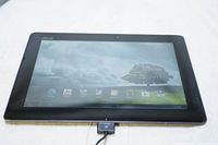 Front view of ASUS TF700T tablet powered on showing Android homescreen.