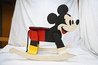 Full side view of vintage handmade wooden Mickey Mouse rocking horse painted in black, white, red and yellow.
