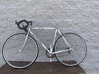 Full left side view of white Concorde Light road bike, shows frame, wheels, crank, seat post