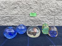 Overview of the blue candle holder and three paperweights arranged in a row