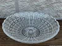 Side angled view showing the bowl's serrated edge and intricate cut glass design with radial and floral motifs.