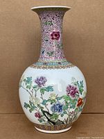 Front view showing rounded body with multicolor floral motif and flared neck with pink floral scroll pattern.