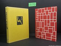 Yellow hardcover Max Ernst coffee table book and red geometric design Mondrian coffee table book side by side