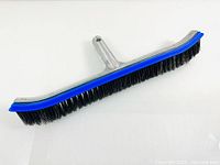 Front view of stainless steel rectangular pool brush head with black bristles and blue trim on a white background, showing bristle side and attachment point.