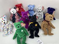 Set of 10 Beanie Babies bears in various colors and patterns, displayed on white surface showing all bears and tags.