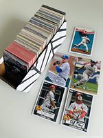 Photo showing a box filled with various sports cards and several baseball cards spread out in front.