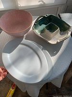 Overall view of the four items: pink bowl, chip and dip dish, two white platters