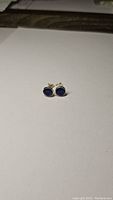 Earrings front view showing blue sapphire stones and silver setting