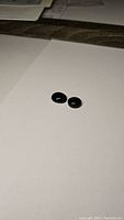 Two oval cabochon black onyx gemstones on white background, showing size difference.