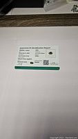 Gemstone ID Identification Report card showing details of the certified sapphire including carat weight, dimensions, clarity, color, and treatment status.