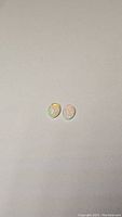 Two oval 8x6mm Ethiopian opal gemstones with bright multicolor rolling flash, displayed on a neutral background.