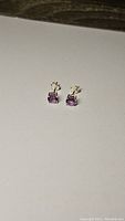 Pair of natural purple amethyst stud earrings set in 925 sterling silver, shown on white background.