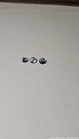 Three round tanzanite gemstones on plain background showing shape and color