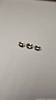 Three oval cut yellow aquamarine (heliodor) gemstones on white background showing size and clarity