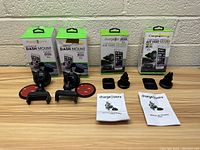 Four Chargeworx phone mounts displayed with boxes and instruction manuals on a wooden surface against a white brick wall.