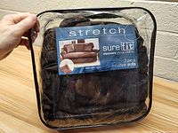 Front view of the packaged SureFit 2 piece T-cushion sofa slipcover showing the brand, product name, and material color.