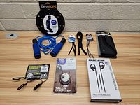 Overview photo showing all items in the lot: weighted jump rope, earbuds, tally counter, hand grips, and pouch.