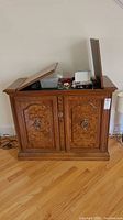 Burrell wood buffet with decorative wood grain and folding top open with contents inside.