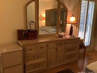 Full view of Stanley dresser with nine drawers and attached triple mirror. Blonde wood finish with brass and ceramic handles.