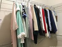 Racks of assorted ladies robes, coats, and outerwear in various fabrics and colors including pastel and dark hues, some with plush and fluffy textures.