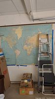 Large vinyl world map mounted on wall, showing North and South America prominently with adjacent continents.