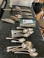 Overview of the entire collection arranged on a table showing spoons, pie servers, ladle and other utensils.