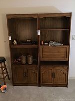 Overview of two wooden shelving units side by side, showing open shelves and lower doors