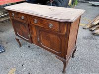 Wooden mid century modern antique cabinet with three drawers and two doors, showing wood grain and light scratches