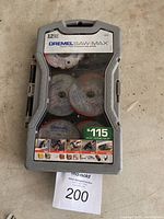 Closed plastic case containing set of 12 Dremel Saw-Max cutting wheels for power tools, showing brand and price sticker.