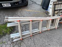 Full view of the folding aluminum ladder showing its sections and red locking components.