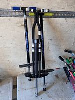 Photo of three pogo sticks with black handles and footrests, silver shafts with Flybar branding, rubber tips shown.