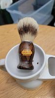 Wood handle shaving brush with pure bristles, labeled 'Sterilized Pure Bristles Made in Germany' in white shaving mug.