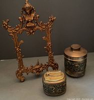 Photo showing heavy metal Art Nouveau style frame along with brass holder and lighter with dolphin motifs